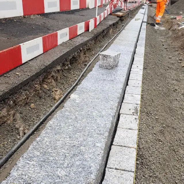 Kante zwischen Pflasterfläche und Rasen, sauber abgeschlossen — Randabschluss im Strassenbau in Wetzikon, Arbeit 8